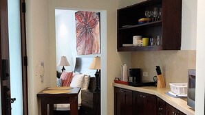 Una cocina compacta con comedor, equipada con refrigerador, microondas y armarios.