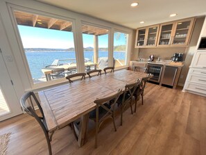 A spacious kitchen with a large wooden table and chairs, a view of the sea, and modern cabinetry. - Luxury Lakeside Home 5BR,4BA, 10+beds. Dock, Kayaks, Fire pit, Hot Tub & more! (Hot Springs)