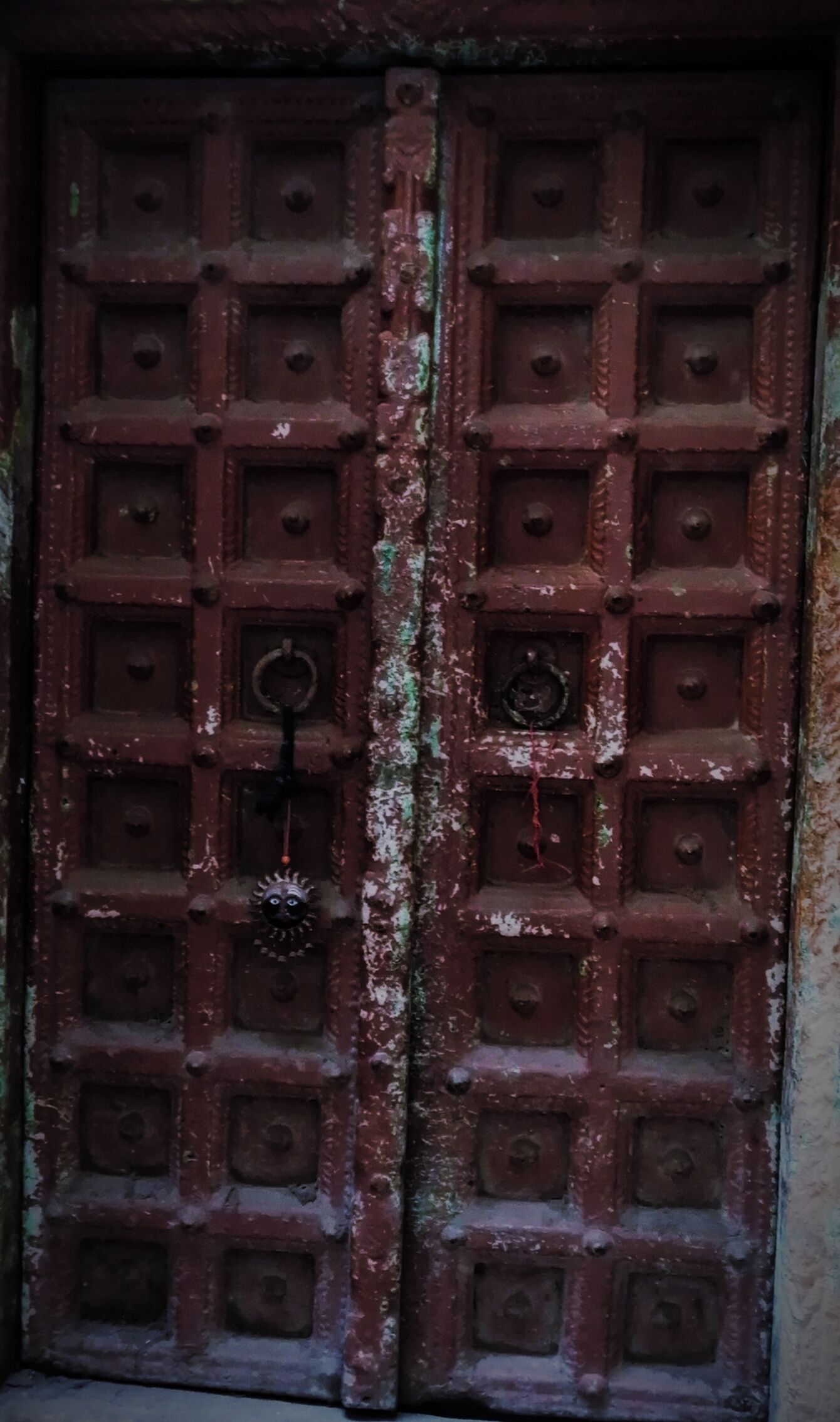 A double door with a grid pattern and a central handle.