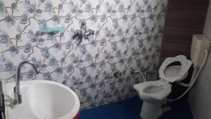 Ein Badezimmer mit Waschbecken, Toilette und blumigem Wandpapier.