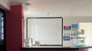 Una recepción con una pared con diseño de mármol, una pared de acento roja y un piso de baldosas.