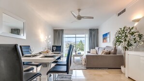 Un salon moderne comprenant un coin repas, un canapé, une table basse et une vue sur l’extérieur.