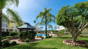 Un jardin bien entretenu, agrémenté d’un kiosque, de palmiers et d’une piscine.