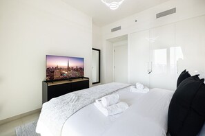 A hotel room with a bed, a television, a wardrobe, and a mirror. - New 4BR |Burj Khalifa View & Pool |Dubai Mall (Dubai)
