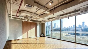 A spacious room with a wooden floor, large windows, and a view of a city skyline. - Dubai Mall Access Burj Khalifa Infinity Pool | 4BR (Dubai)
