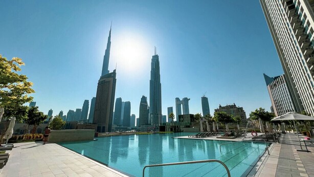 A swimming pool with a city skyline in the background. - Dubai Mall Access Burj Khalifa Infinity Pool | 4BR (Dubai)