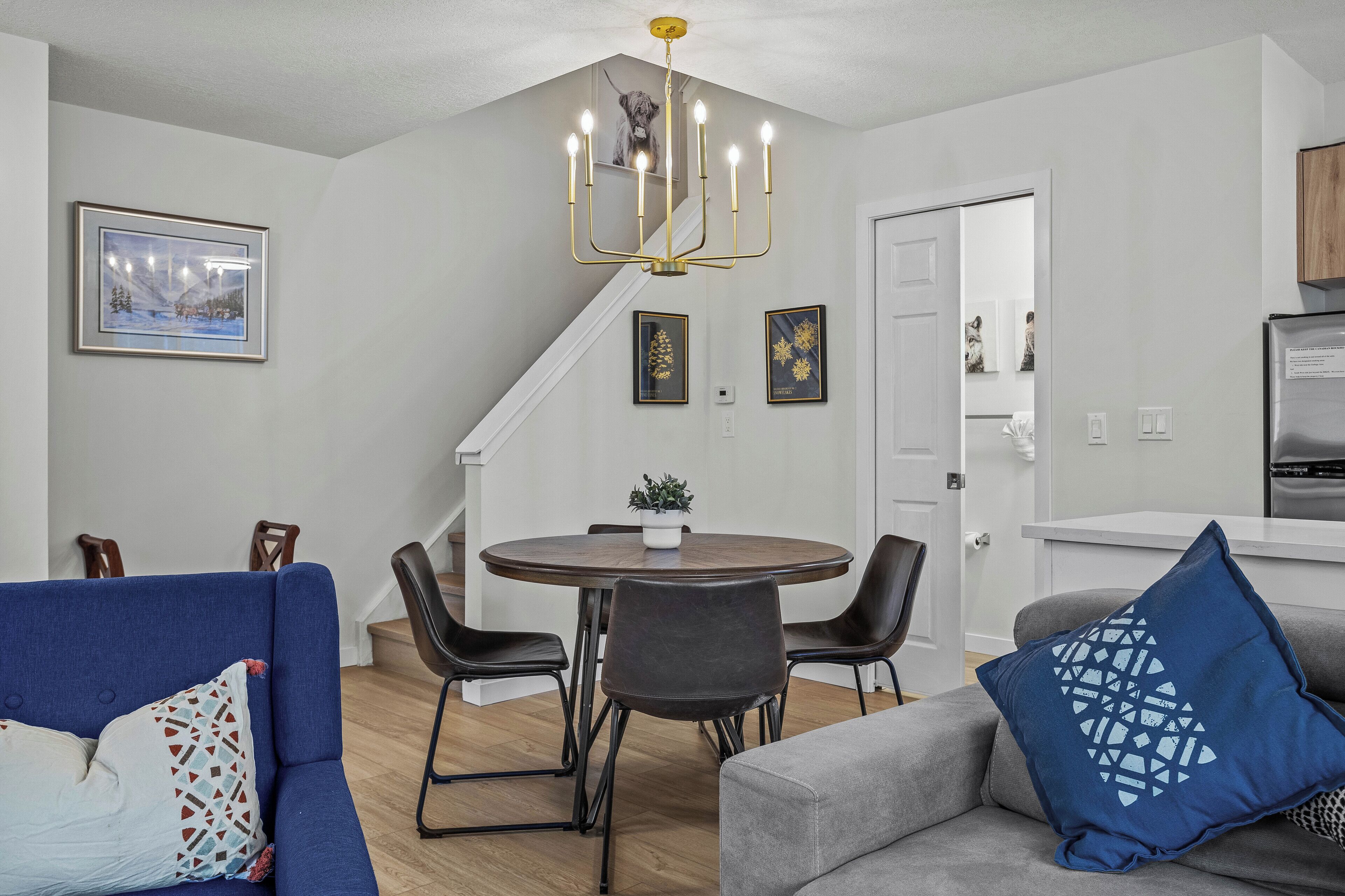 Una sala moderna con comedor, una escalera y una cocina.