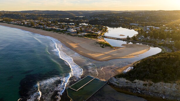 An aerial view of a coastal town with a beach, a lake, and residential areas. - Seaside apartment, 100m to beach (Narrabeen)