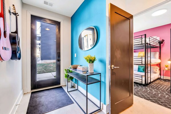 A room with a black metal console table, a mirror, and a potted plant.