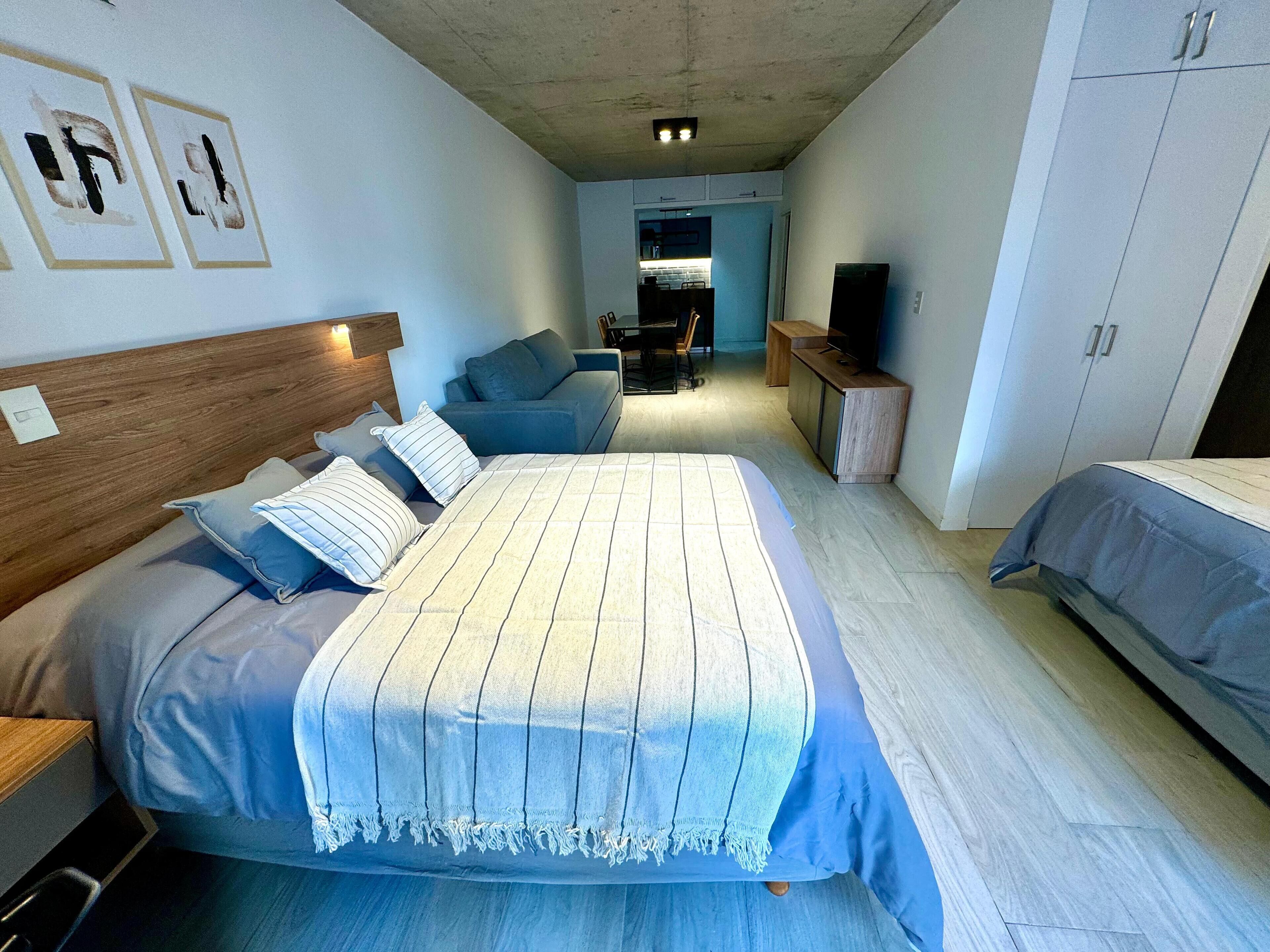 A bedroom with a bed, a sofa, a TV, and a wardrobe.