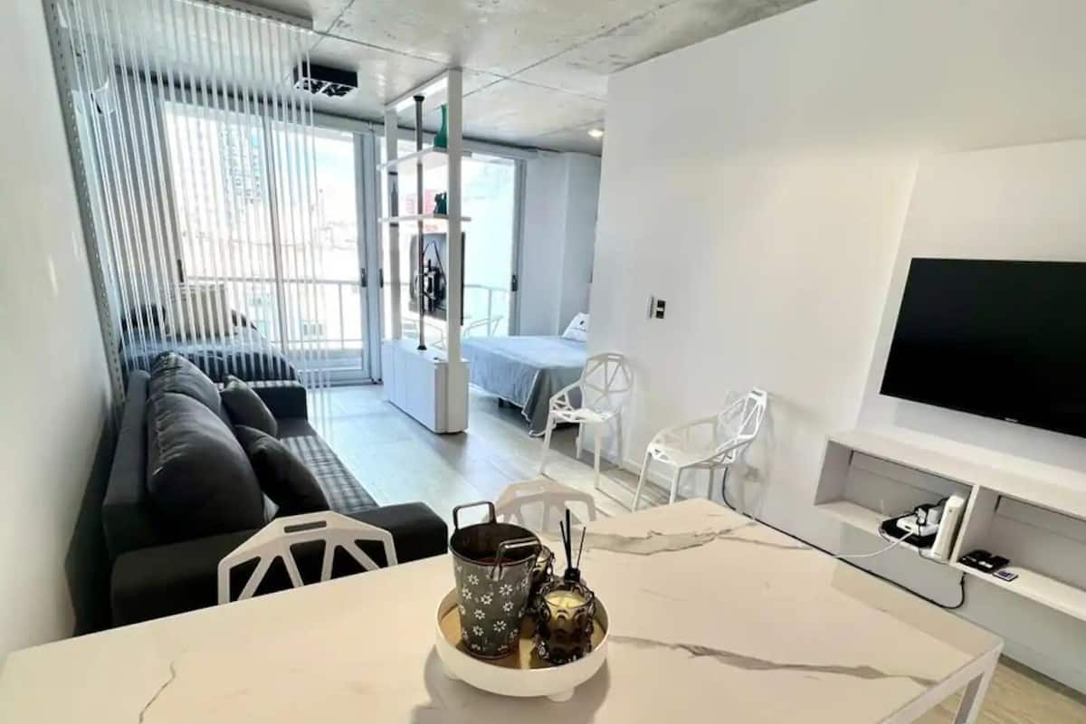 A modern living room with a white marble table, a sofa, and a TV.