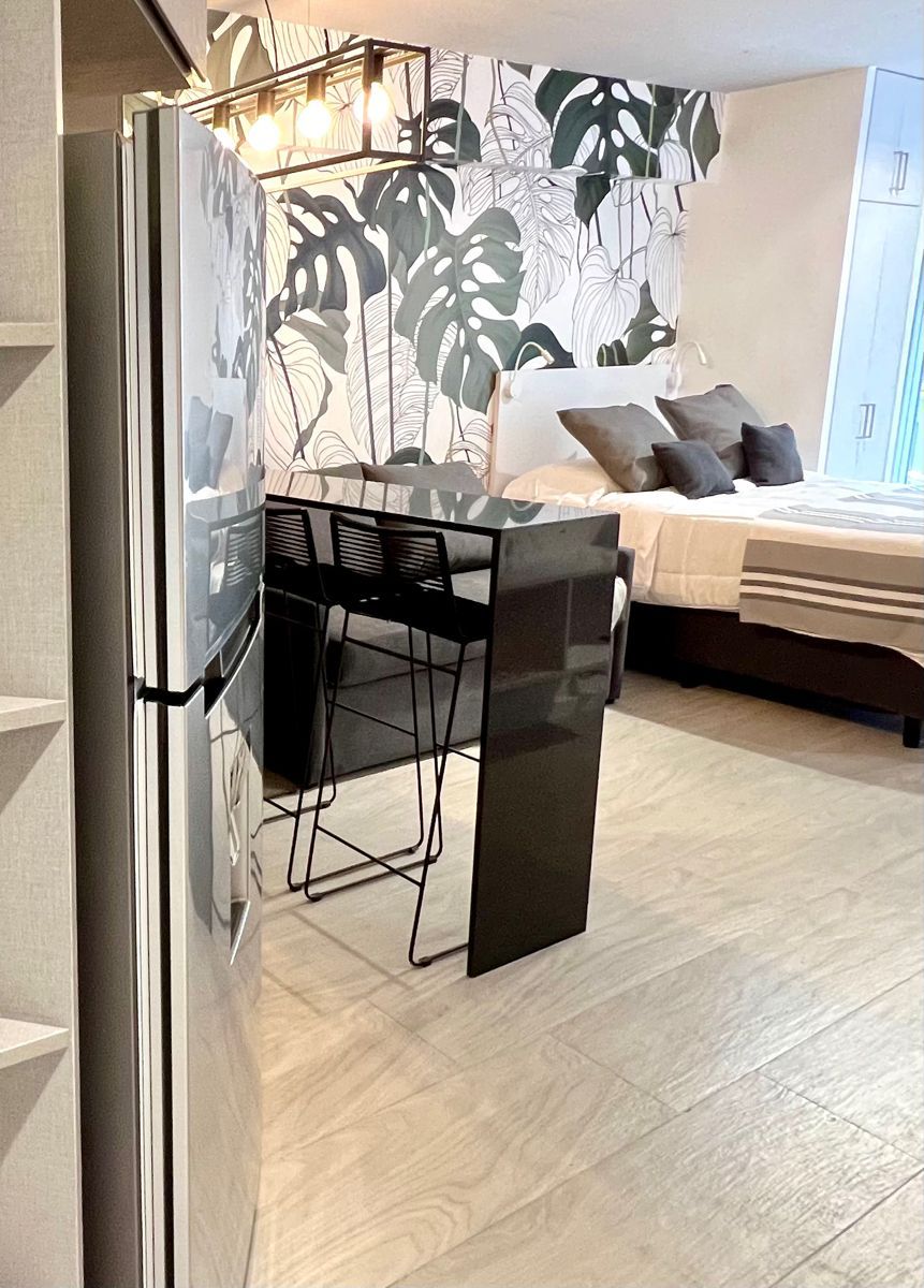Une pièce de taille modeste, comprenant un lit, un petit bureau et une chaise.