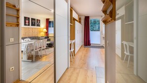 Un interior moderno con comedor, cocina y vistas a través de una puerta abierta.