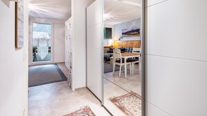 A modern interior with a dining area, a sofa, and a view through a glass door.