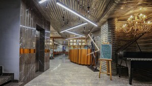 A modern lobby with a marble floor, a reception desk, a piano, and a sculpture. - Aceotel Select Aria - A Luxury Boutique Hotel (Bhopal)
