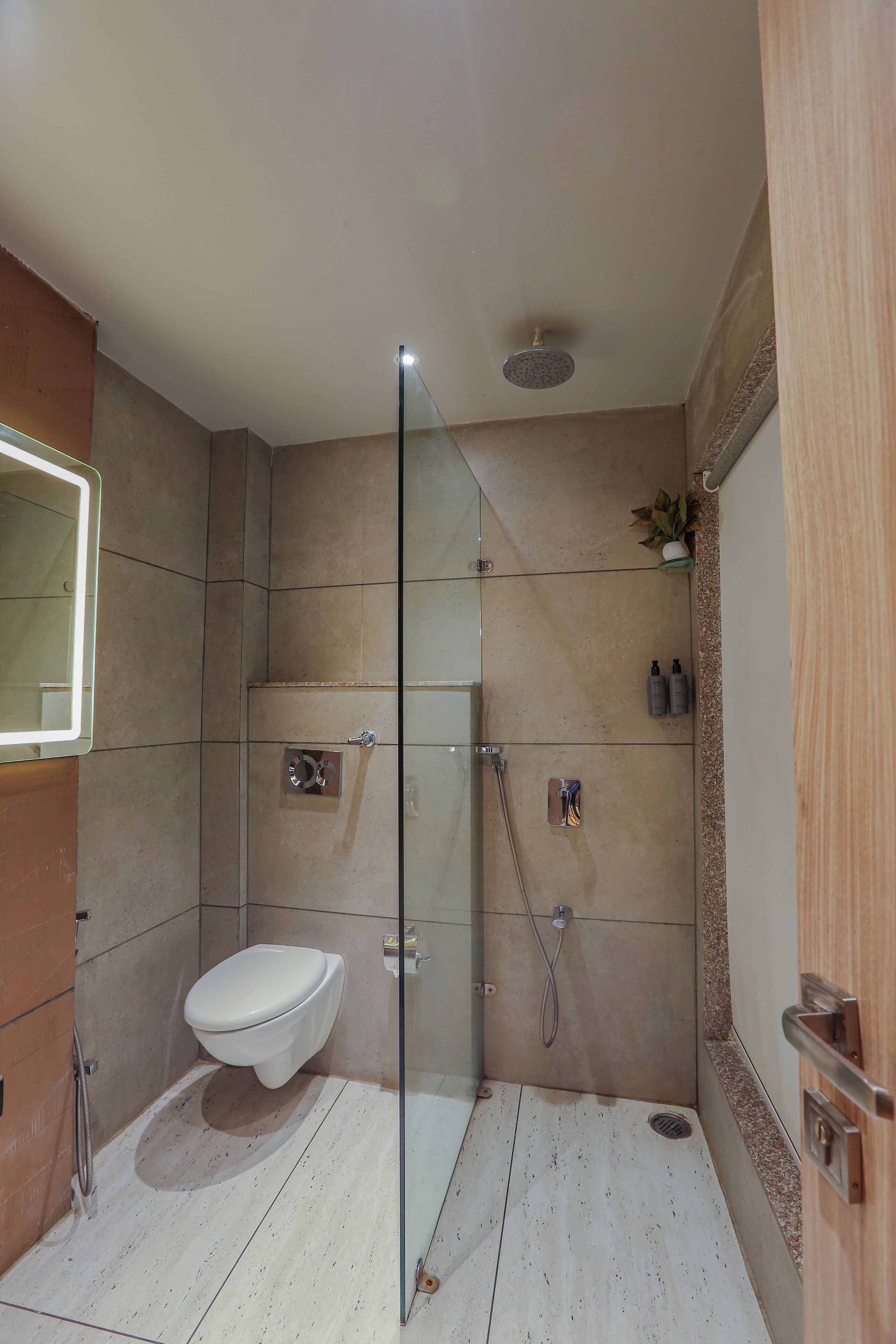 A modern bathroom with a glass-enclosed shower, a toilet, and a sink.