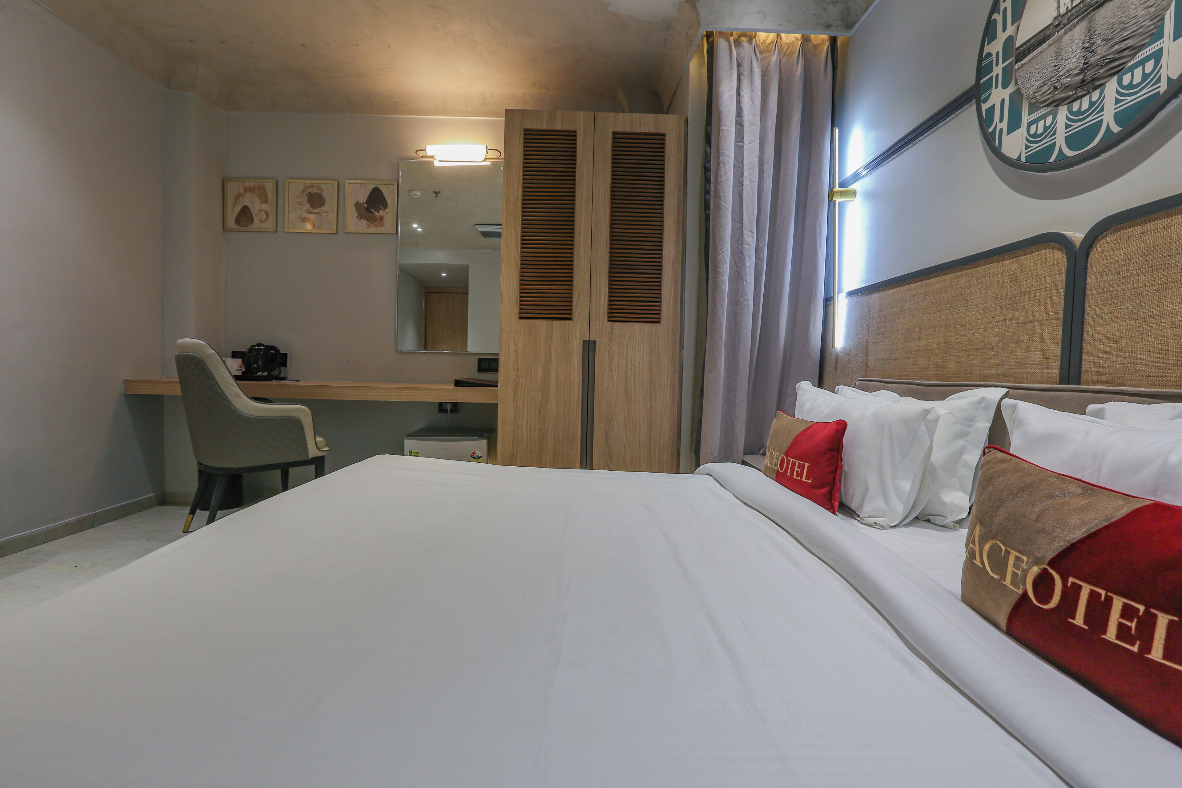 Una habitación de hotel con cama, escritorio, silla y armario.