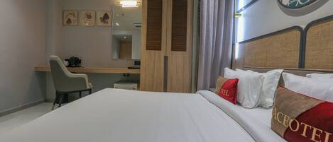 Una habitación de hotel con cama, escritorio, silla y armario.