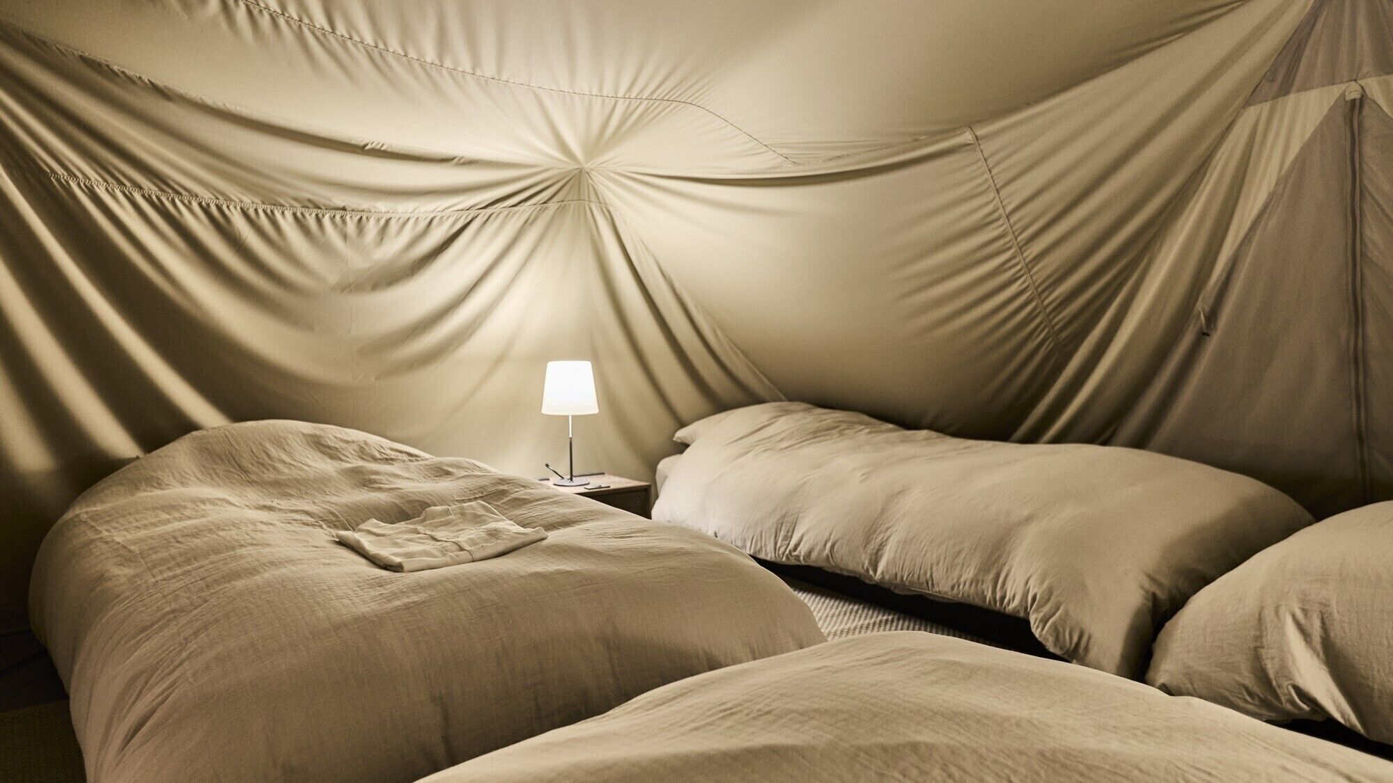 Una habitación con cama, mesita de noche y lámpara.
