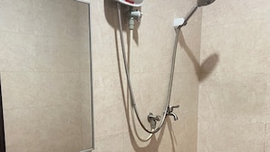 Un baño con un lavamanos blanco, una ducha de mano y un grifo empotrado.