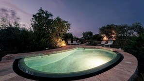 A swimming pool with two lounge chairs and a light source in the background. - Borgo Dell Agrumeto 8 Emma Villas (Ostuni)