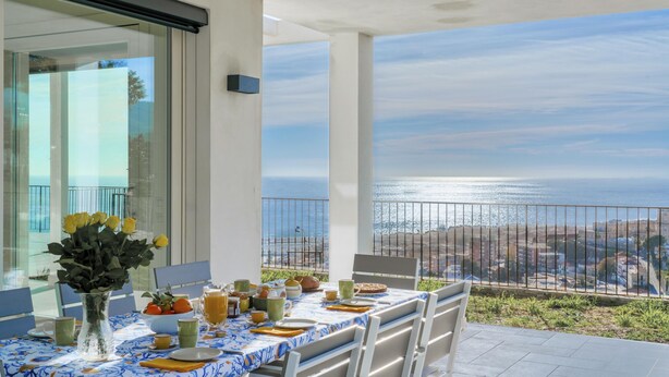 A balcony with a table set for breakfast, overlooking a coastal view. - Villa Gioia 8 Emma Villas (Sanremo)