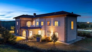 A two-story house with a balcony, a stone pathway leading to the entrance, and a small garden area. - Cascina Moglia 8 1 Emma Villas (Carpeneto)