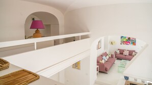 A multi-level living space with a staircase, a pink sofa set, and a lamp. - Villa Borboleta By Elite Villas (Capri)