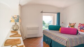 A bedroom with a bed, a window, a heater, and a lamp. - Villa Borboleta By Elite Villas (Capri)