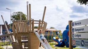 A playground with a slide and climbing structures. - luxury chalet on a cosy campsite near the sea (Westerland)