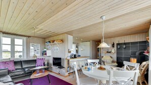 Ein gemütliches Blockhauss-Interieur mit Wohnbereich, Essbereich und Küche.