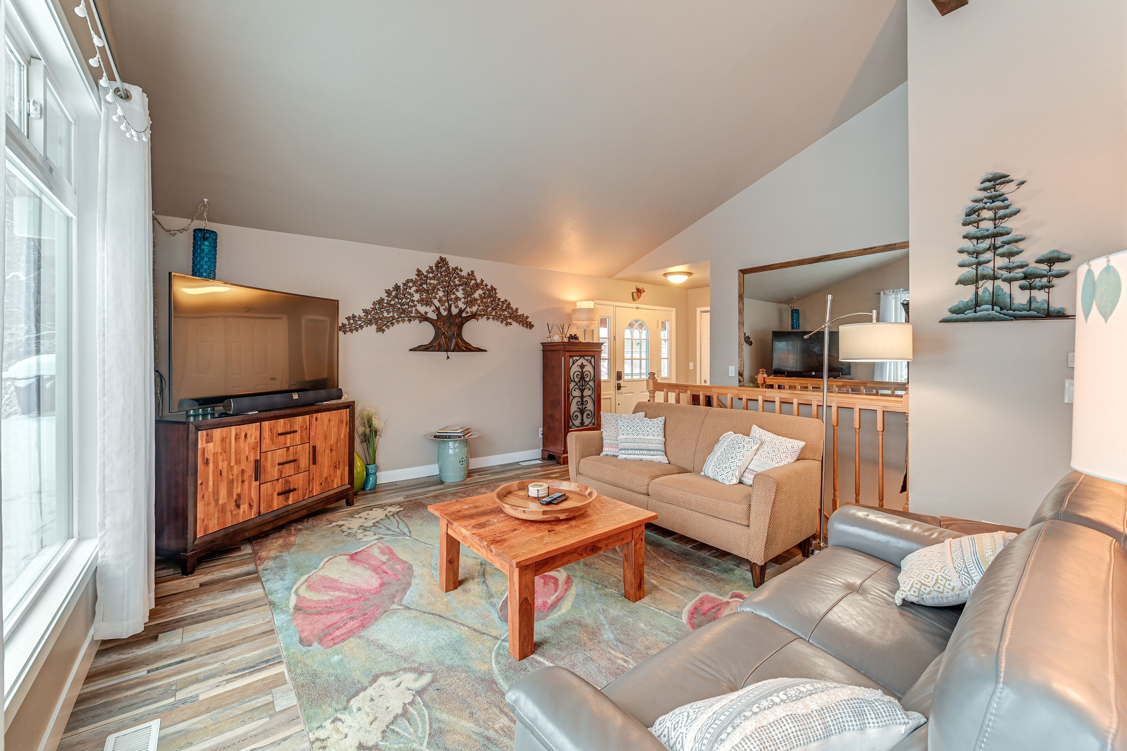 A living room with a wooden coffee table, a sofa, and a television on a wooden cabinet.