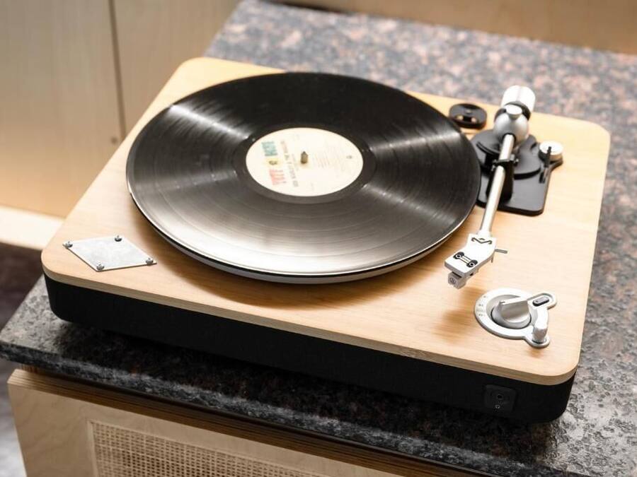 Un giradischi con un disco in vinile su una superficie in legno.