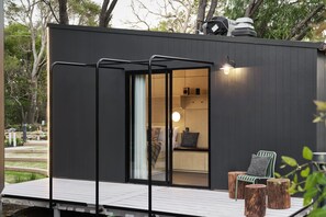 A compact, modern cabin with a sliding glass door leading to a cozy interior. - Southcamp (Dunsborough)