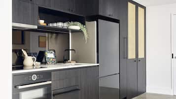 A modern kitchen with dark wood cabinets, a Bosch oven, and a refrigerator.