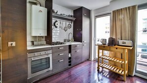 A modern kitchen with a built-in oven, a coffee maker, and a toaster on a wooden table. - Appart 4pers#St Antoine#Bastille#Nation (Paris)
