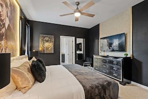 A bedroom with a bed, a ceiling fan, a dresser, and a large framed picture on the wall. - 6BD Solterra Resort Near Disney (ST 5113) (Davenport)