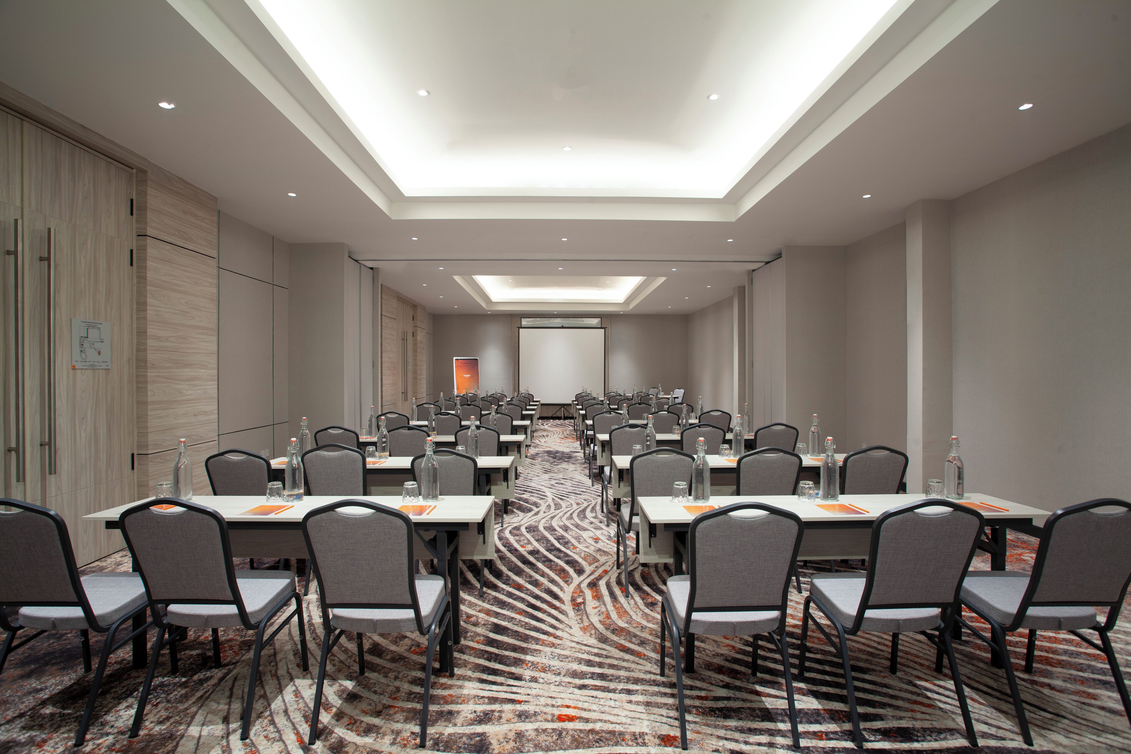 A conference room with tables and chairs, a patterned carpet, and a skylight ceiling.