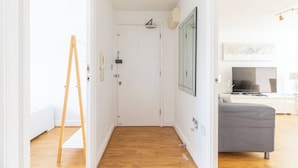 A hallway with a white door, a telephone, and a mirror on the wall. - London Oasis in Woolwich Arsenal  (London)