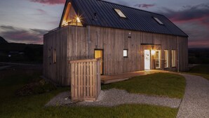 A modern wooden cabin with a sloped roof, large windows, and a wooden deck. - 3 The Vista, Willingcott Nr Woolacombe - Hot tub/ Pet friendly/ On-site pool/ EV Charger/ Ecohome (Woolacombe)
