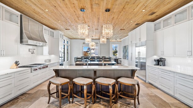 A spacious kitchen with a large island, wooden ceiling, and modern lighting. - Crystal Del Mar. New! Private Pool, Gulf Views (Destin)