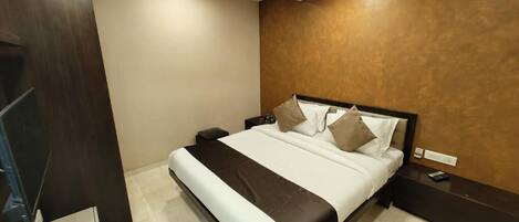 A hotel room with a bed, bedside tables, a ceiling fan, and a sign indicating the room number.