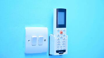 Un panel de control fijado a la pared con un teclado y un interruptor de luz.
