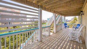 A wooden deck with white railings and blue accents, featuring outdoor seating and a staircase. - Renovated - Seaside 5BR Caribbean Escape near the Rodanthe Pier (Rodanthe)