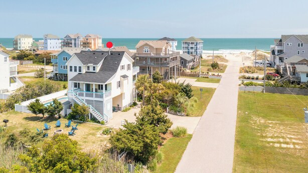 A coastal residential area with houses, a clear sky, and a beach in the background. - Renovated - Seaside 5BR Caribbean Escape near the Rodanthe Pier (Rodanthe)