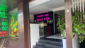 A hotel entrance with a neon sign, a staircase, and potted plants. - Ngoc Yen Hotel by Bay Luxury (Ho Chi Minh City)