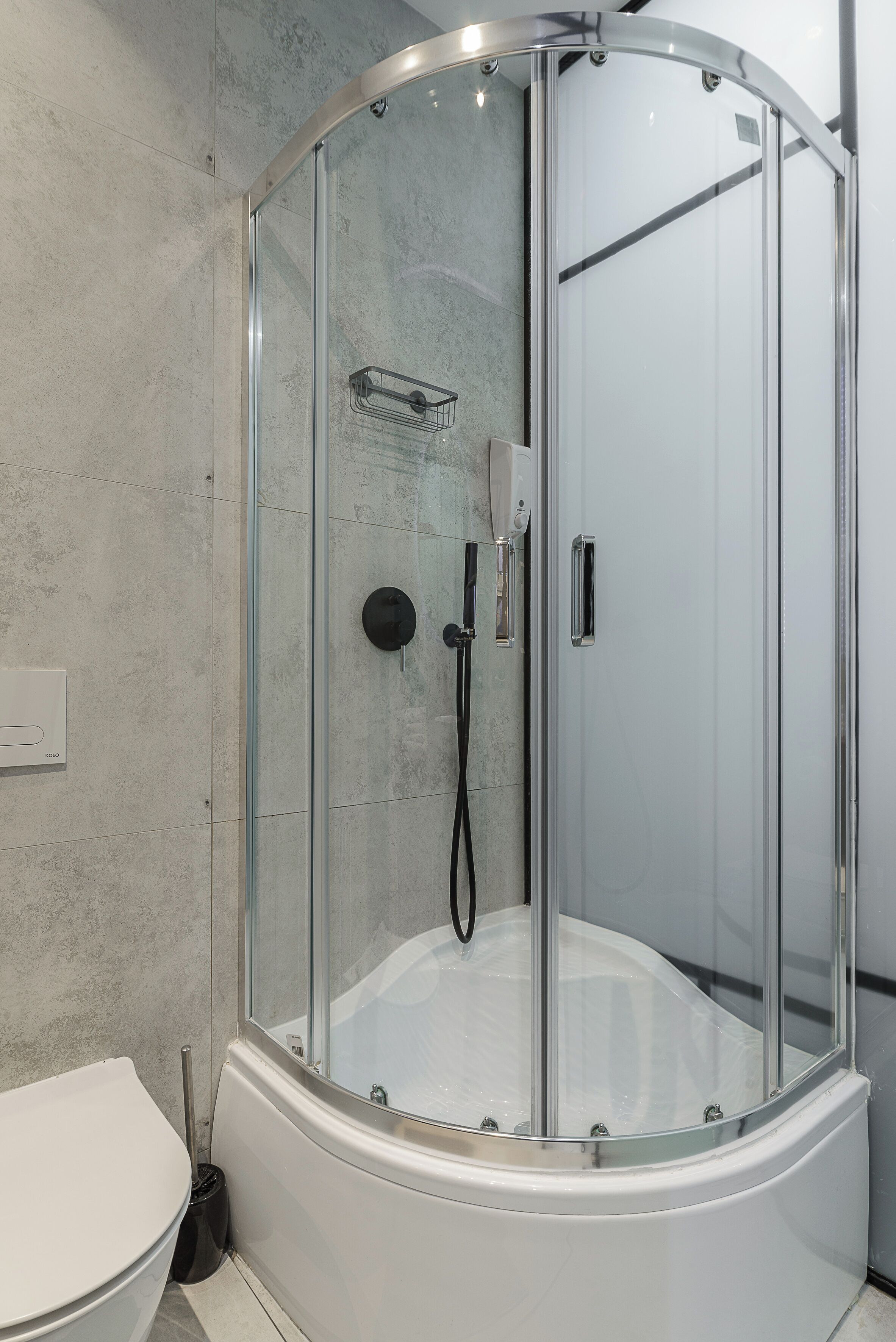 A modern bathroom with a glass-enclosed shower, a white toilet, and a towel rack.
