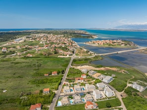 An aerial view of a coastal town with residential areas, a marina, and a bridge.