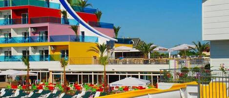 Een buitenzwembad, parasols bij het zwembad en ligstoelen