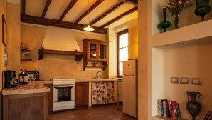 Una cocina con armarios de madera, una estufa, un refrigerador y un ventanal.